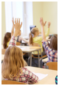 Children in class with hands raised